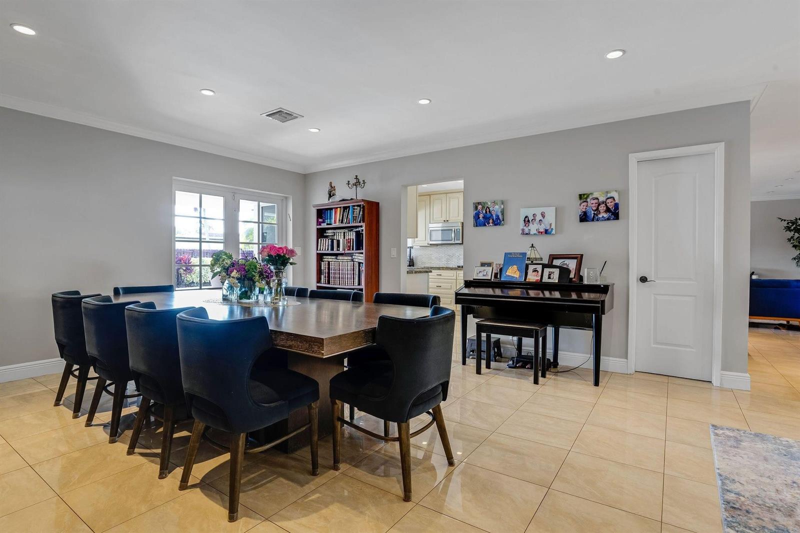 A dining room features a large wooden table, dark chairs, a piano, and tile flooring — 4000 N 36th Avenue, Hollywood FL 33021, HOLLYWOOD, FL