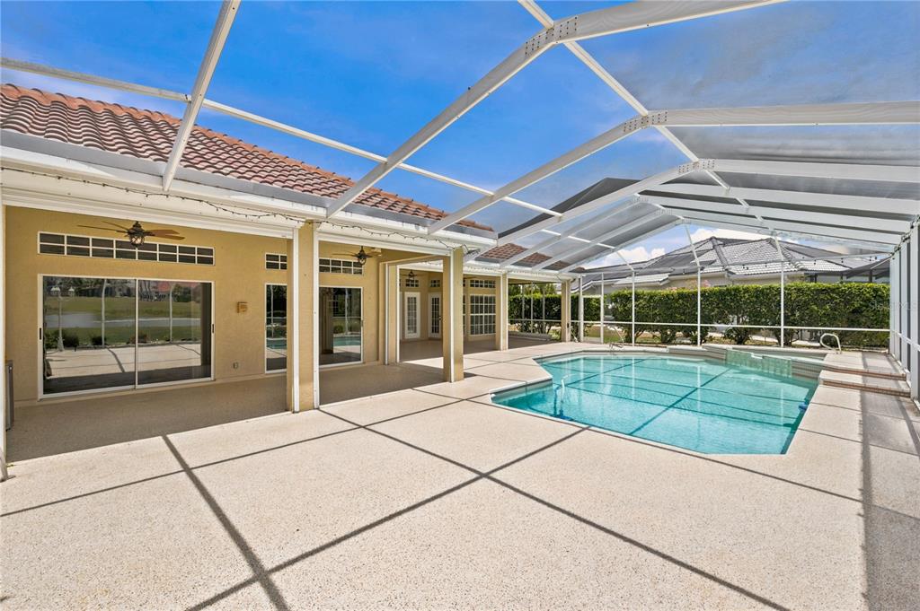 A screened-in patio features a swimming pool, concrete flooring, and sliding glass doors — 2116 PLATINUM DRIVE, SUN CITY CENTER, FL