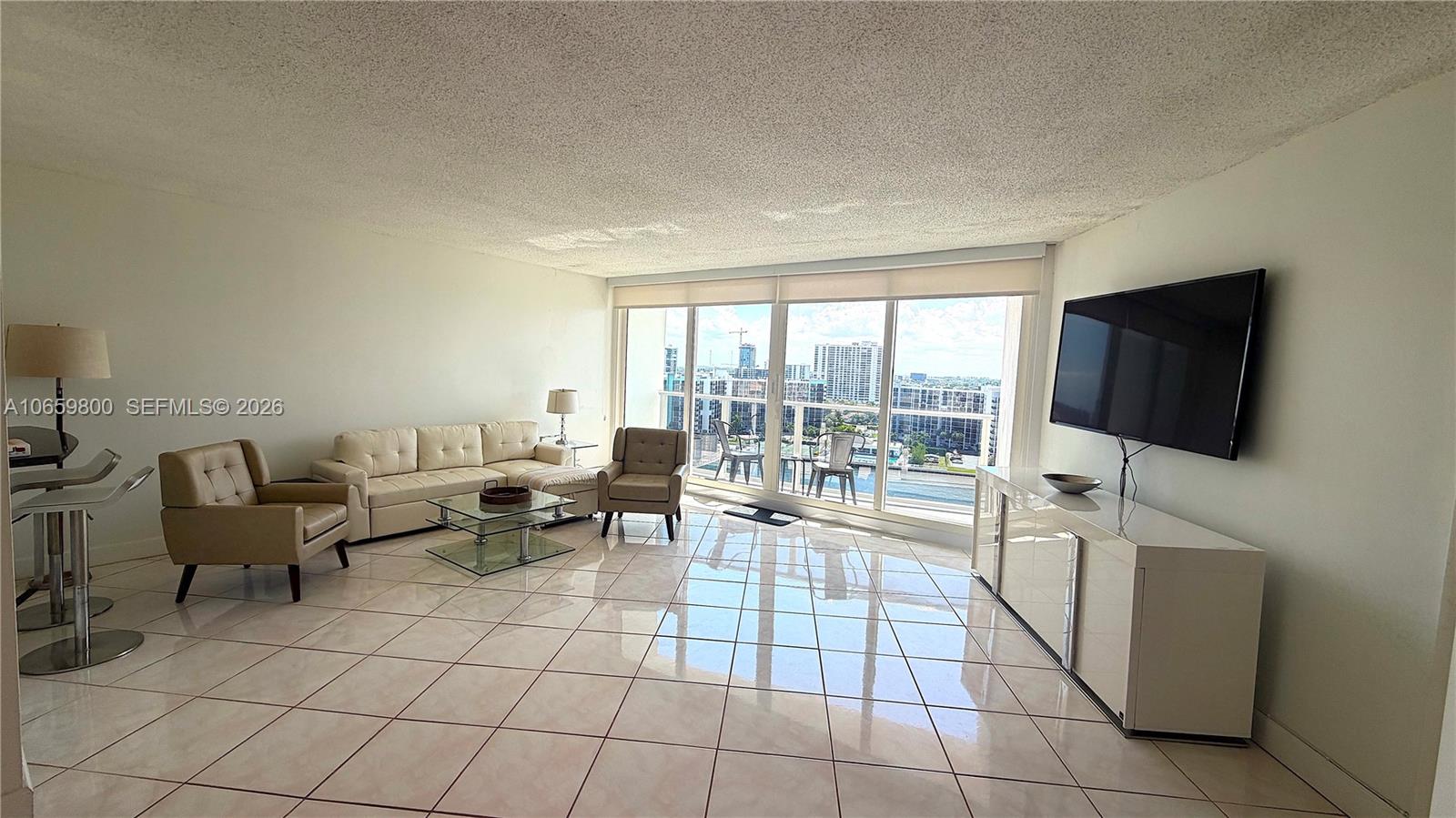 A living room features white tile floors, a sectional sofa, and floor-to-ceiling windows — 3505 S Ocean Dr # 1403, Hollywood FL 33019, HOLLYWOOD, FL