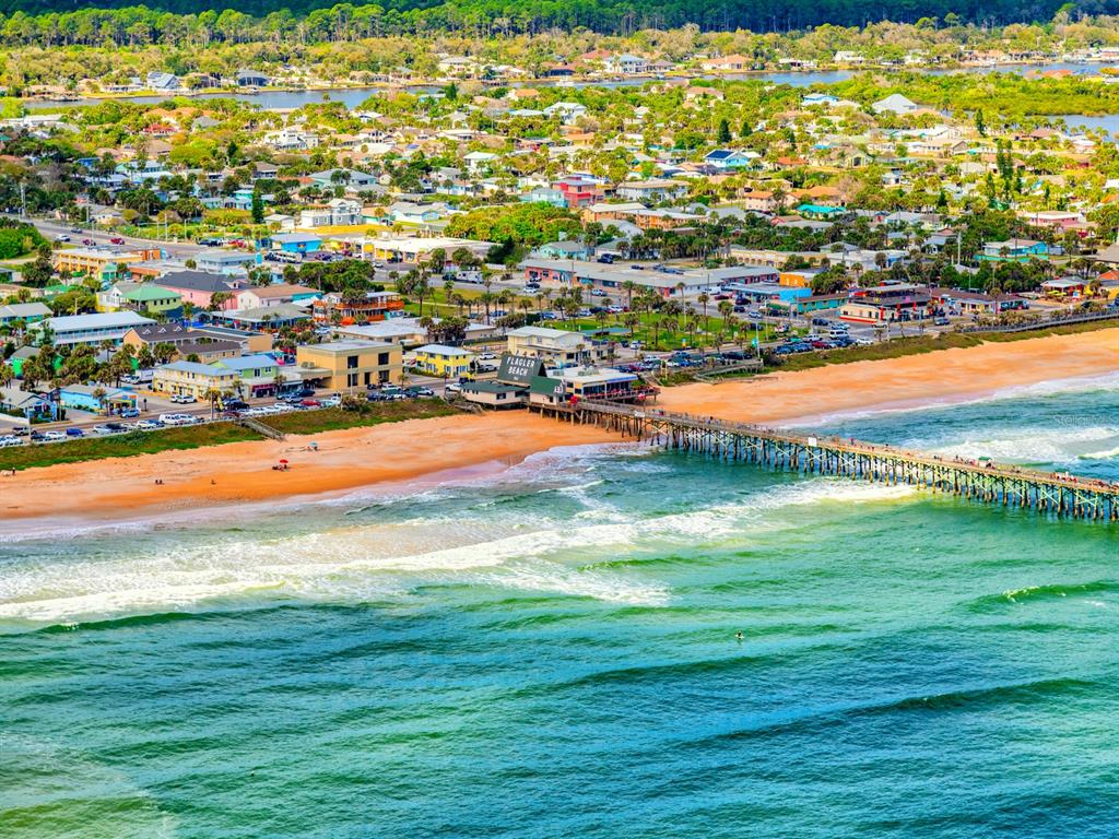 An aerial view of a coastal town featuring a long pier extending into the ocean — 100 TEQUESTA COURT, PALM COAST, FL