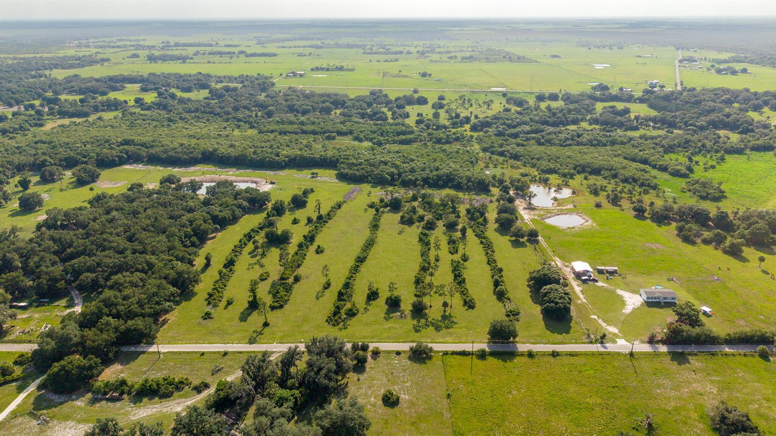 An aerial view shows a rural property with green pastures, scattered trees, and a small house — 0 NW 190th Road, Okeechobee FL 34972, OKEECHOBEE, FL