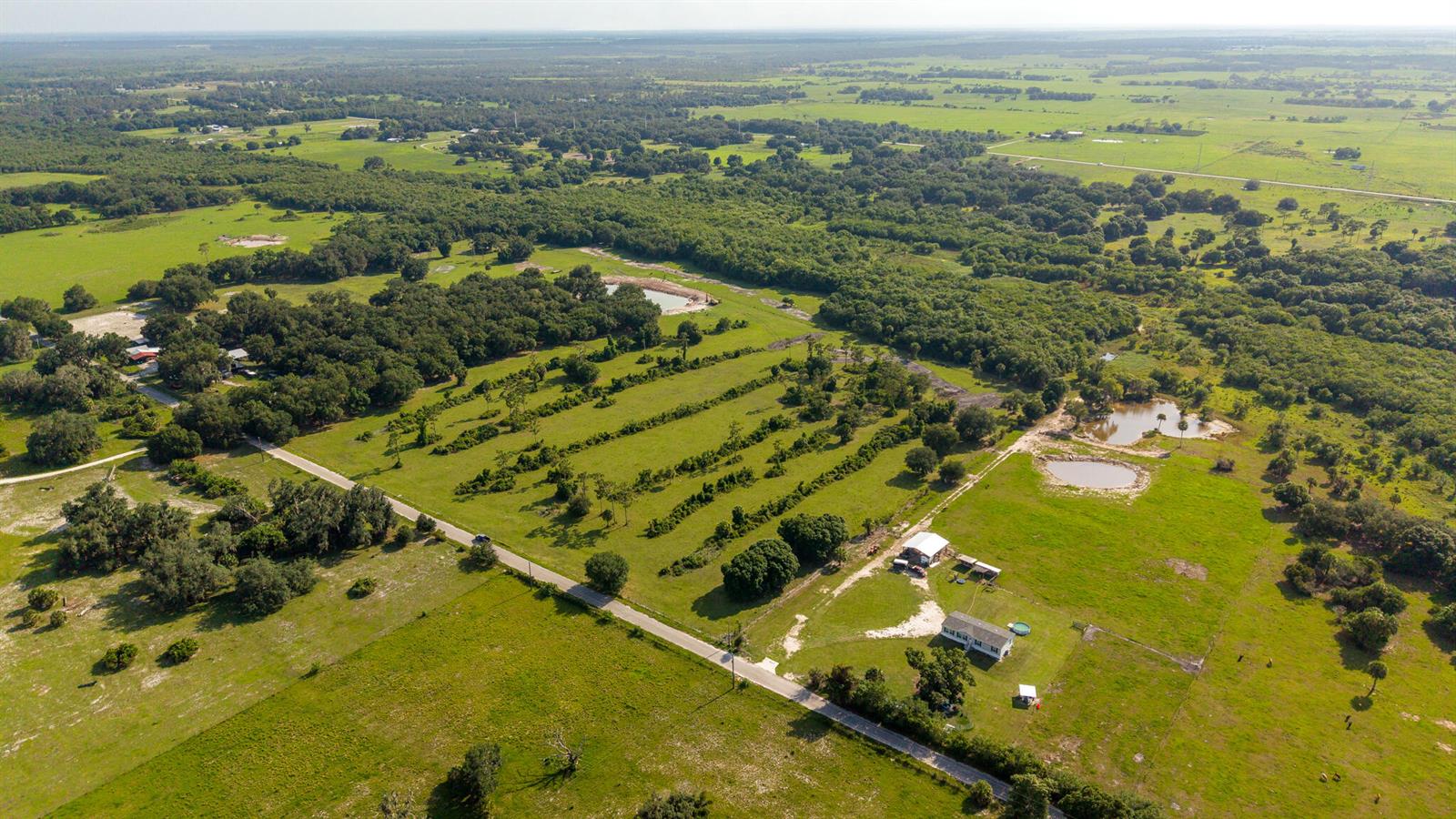 An aerial view shows a rural property with a house, outbuildings, ponds, and scattered trees — 0 NW 190th Road, Okeechobee FL 34972, OKEECHOBEE, FL