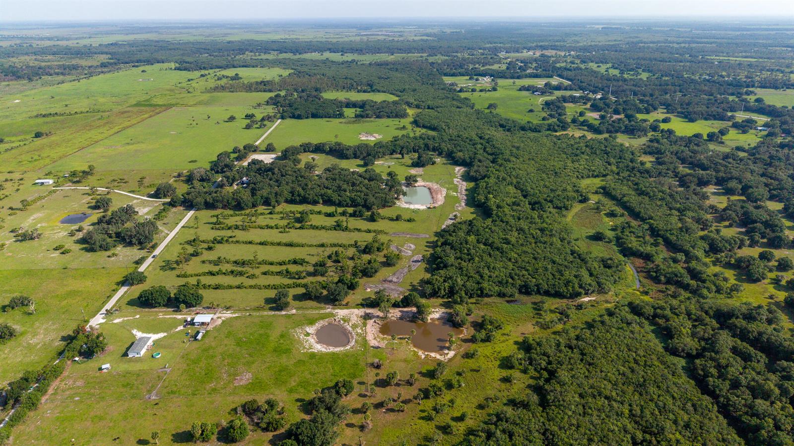 An aerial view shows a rural property with green pastures, scattered trees, and several ponds — 0 NW 190th Road, Okeechobee FL 34972, OKEECHOBEE, FL