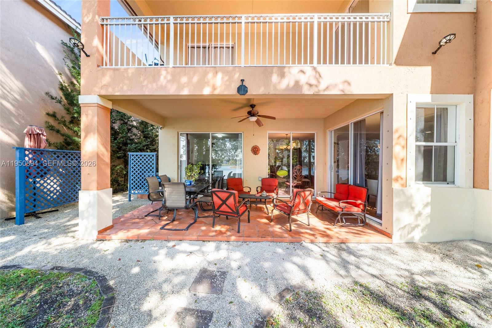 A covered balcony features terracotta tile flooring, a white metal railing, and a water view — 16062 SW 43rd Ter, Miami FL 33185, MIAMI, FL
