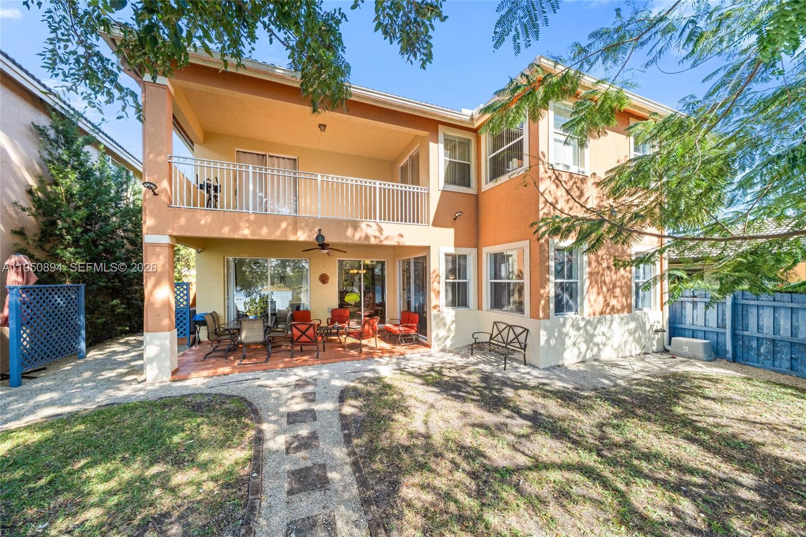 A covered patio features terracotta tile flooring, outdoor furniture, and sliding glass doors — 16062 SW 43rd Ter, Miami FL 33185, MIAMI, FL
