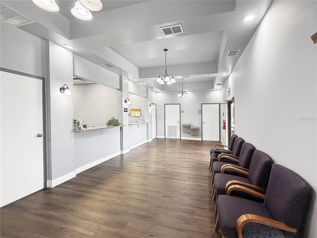 A waiting room features dark wood-look flooring, rows of chairs, and a reception desk — 2320 NORTH BOULEVARD W UNIT A, DAVENPORT, FL