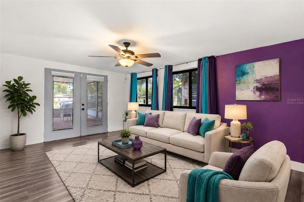 A living room features a beige sofa, purple accent wall, and a ceiling fan — 2617 S LAUREL AVENUE, SANFORD, FL