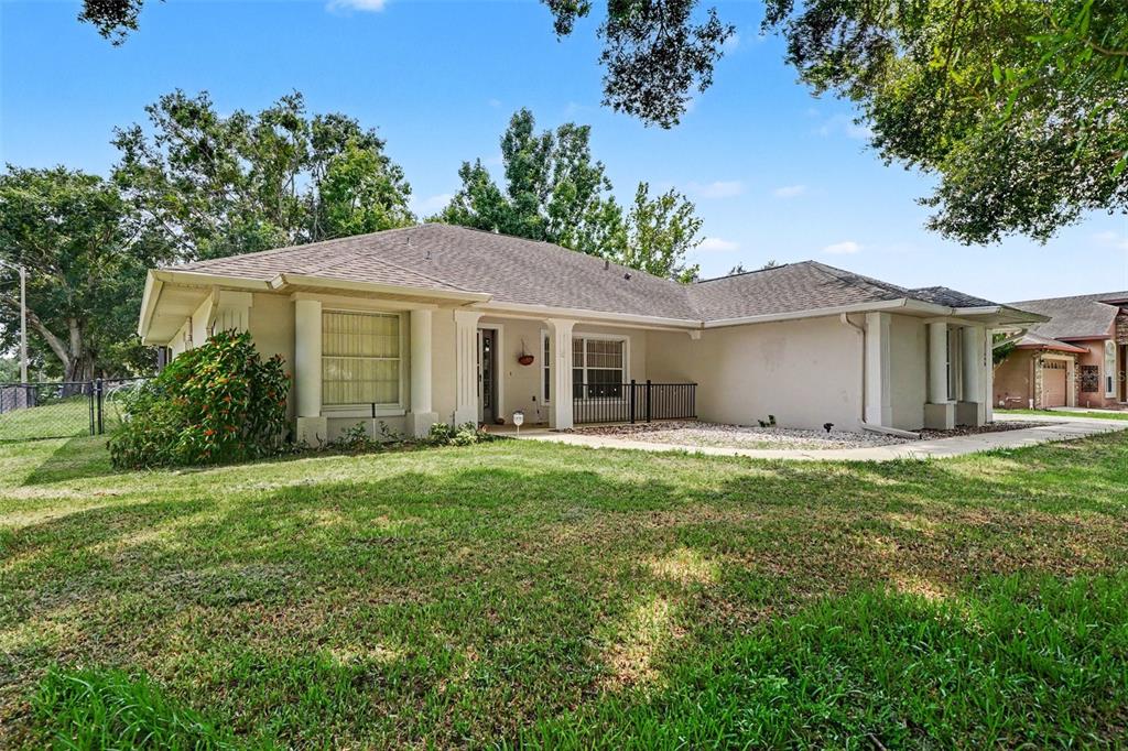 A single-story house with a beige stucco exterior, a covered entryway, and a grassy yard — 11648 GRAND BAY BOULEVARD, CLERMONT, FL