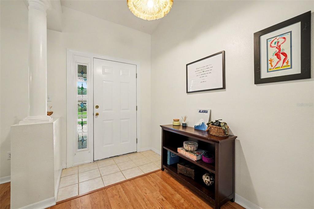 An entryway features a white front door with a sidelight, tile flooring, and a console table — 11648 GRAND BAY BOULEVARD, CLERMONT, FL
