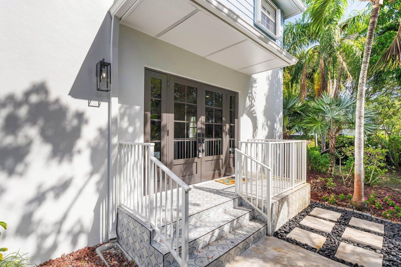 A house exterior features a covered entryway with patterned tiled steps and white railings — 1920 Spanish Trail, Delray Beach FL 33483, DELRAY BEACH, FL