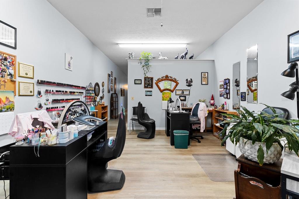 A nail salon features two manicure stations, wood-look flooring, and various wall-mounted decor — 3438 N CITRUS AVENUE, CRYSTAL RIVER, FL