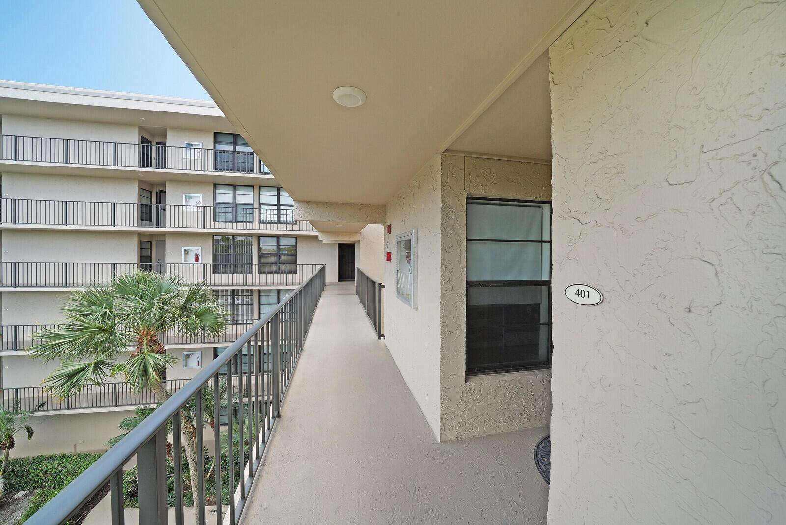 An exterior walkway leads to unit 401 in a multi-story apartment building with metal railings — 8 Royal Palm Way # 401, Boca Raton FL 33432, BOCA RATON, FL