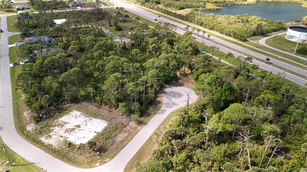 An aerial view shows a vacant, wooded residential lot at the end of a cul-de-sac — 103 HAWK DRIVE, ROTONDA WEST, FL