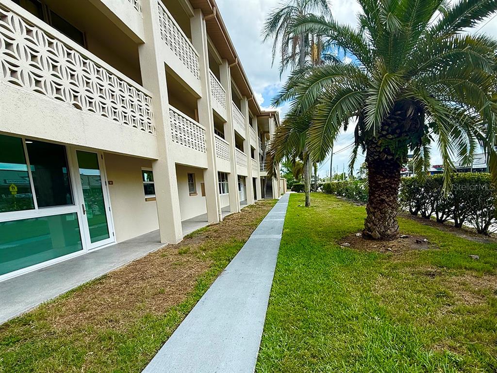 A multi-story building with decorative concrete screens and a palm tree on the lawn — 4455 DUHME ROAD UNIT 103, ST PETERSBURG, FL