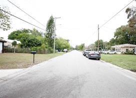 A view of a residential street with houses, trees, and parked cars — 3806 W WALLACE AVENUE, TAMPA, FL