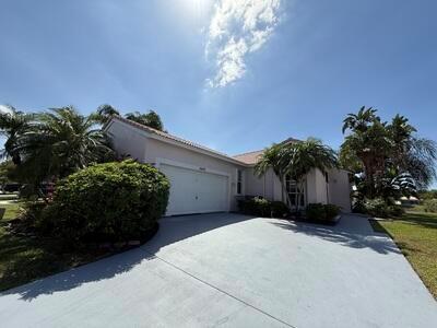 A single-story house with a white garage door, a paved driveway, and surrounding palm trees — 10839 Madison Drive, Boynton Beach FL 33437, BOYNTON BEACH, FL