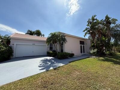 A single-story house with a two-car garage, light-colored stucco walls, and palm trees — 10839 Madison Drive, Boynton Beach FL 33437, BOYNTON BEACH, FL