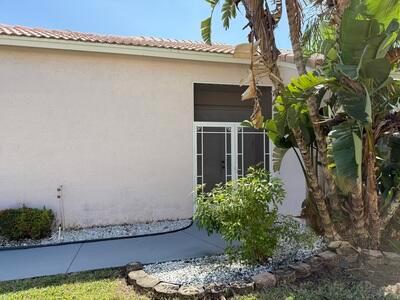 A light-colored house exterior features a white-framed glass door and a curved concrete walkway — 10839 Madison Drive, Boynton Beach FL 33437, BOYNTON BEACH, FL