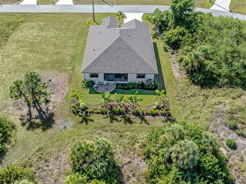An aerial view shows a single-story house with a shingled roof and landscaped backyard — 171 SPRING DRIVE, ROTONDA WEST, FL