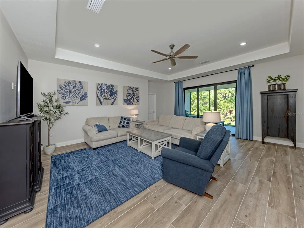 A living room features a blue area rug, light-colored sofas, and a blue recliner — 171 SPRING DRIVE, ROTONDA WEST, FL