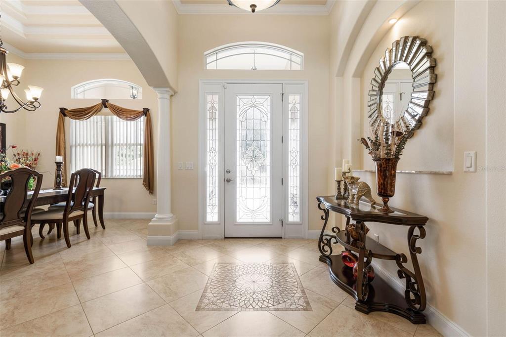 A bright foyer features tile flooring, a decorative entryway, and a console table with mirror — 60 FENIMORE LANE, PALM COAST, FL