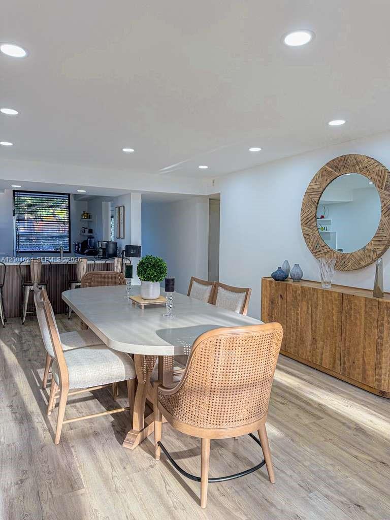 A dining room features a light-colored table, cane-backed chairs, and a large circular mirror — 1721 Whitehall Dr # 101, Davie FL 33324, DAVIE, FL