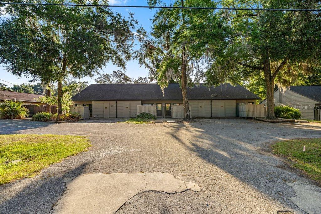 A single-story multi-unit building with a paved parking lot and surrounding trees — 4111 SE 22ND AVENUE, OCALA, FL