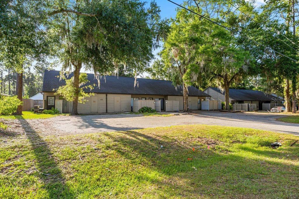 A single-story multi-unit residential building with beige siding and a parking lot in front — 4111 SE 22ND AVENUE, OCALA, FL