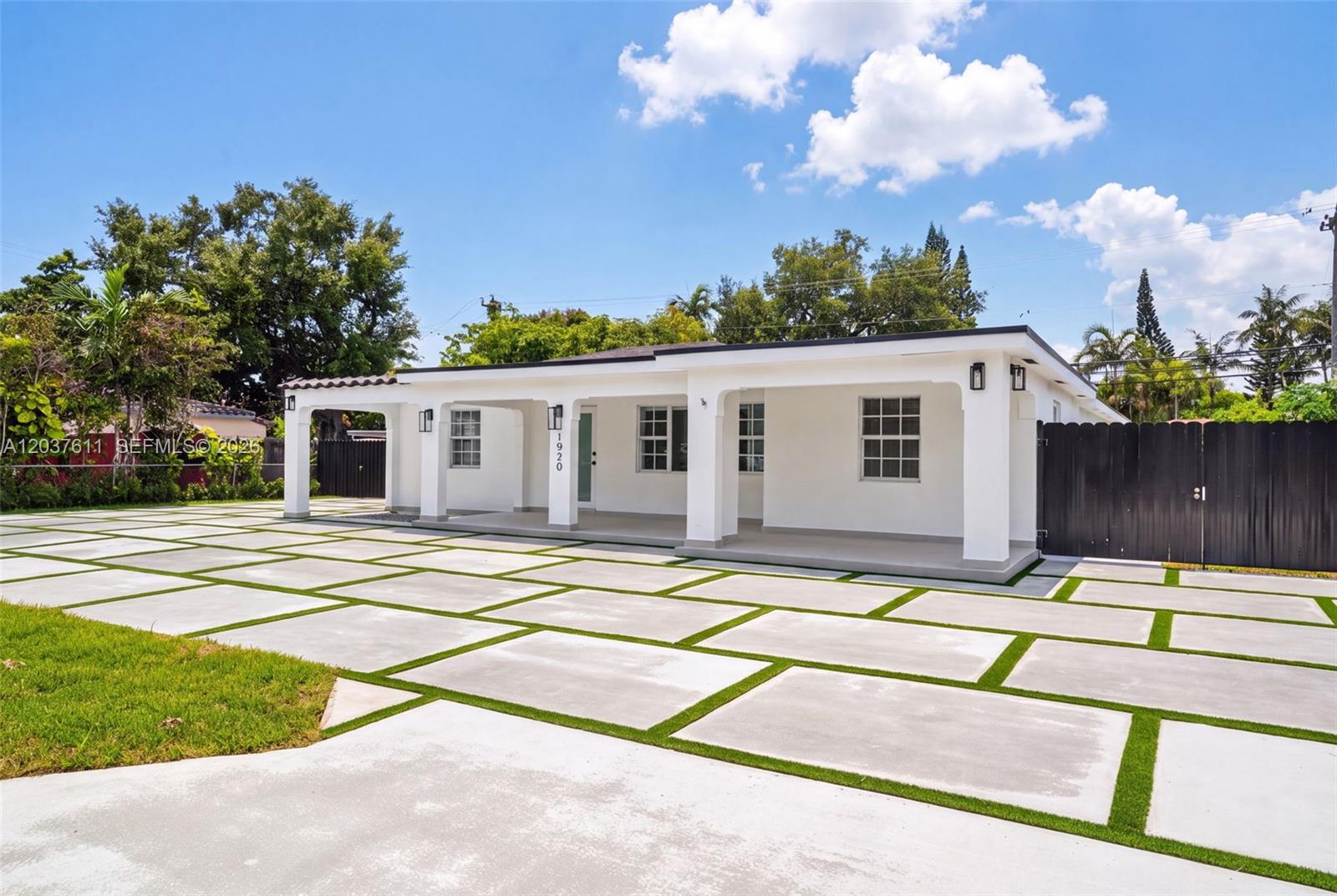 A white single-story house features a covered porch and a large concrete paver driveway — 1920 SW 67th Ave, Miami FL 33147, MIAMI, FL