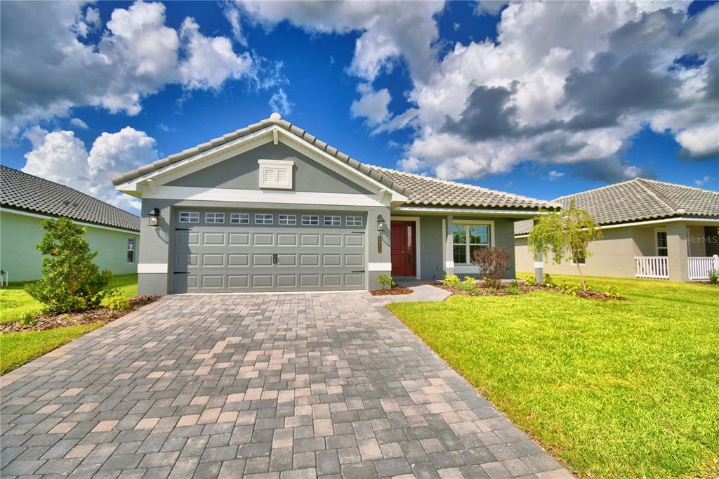 A single-story house with a gray exterior, a tiled roof, and a two-car garage — 4467 JULIANA LAKE DRIVE, AUBURNDALE, FL