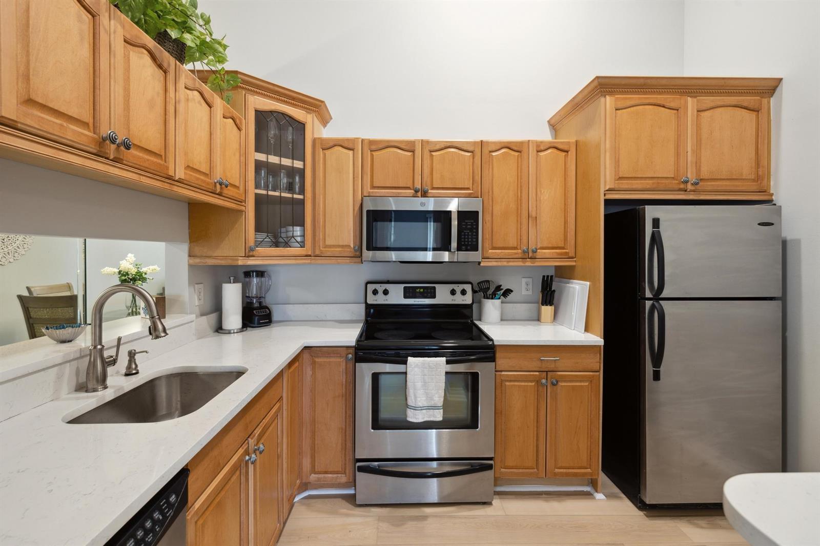 A kitchen features light wood cabinets, stainless steel appliances, and white quartz countertops — 6271 Chasewood Drive # F, Jupiter FL 33458, JUPITER, FL