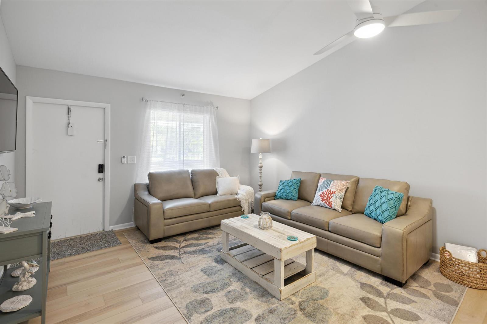 A living room features light gray walls, a tan sofa and loveseat, and a patterned rug — 6271 Chasewood Drive # F, Jupiter FL 33458, JUPITER, FL