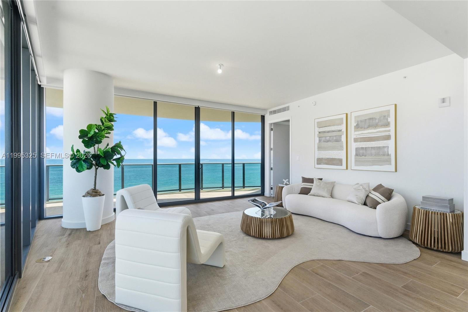 A bright living room features white furniture, a curved rug, and floor-to-ceiling ocean views — 900 N Ocean Blvd # 1506, Pompano Beach FL 33062, POMPANO BEACH, FL