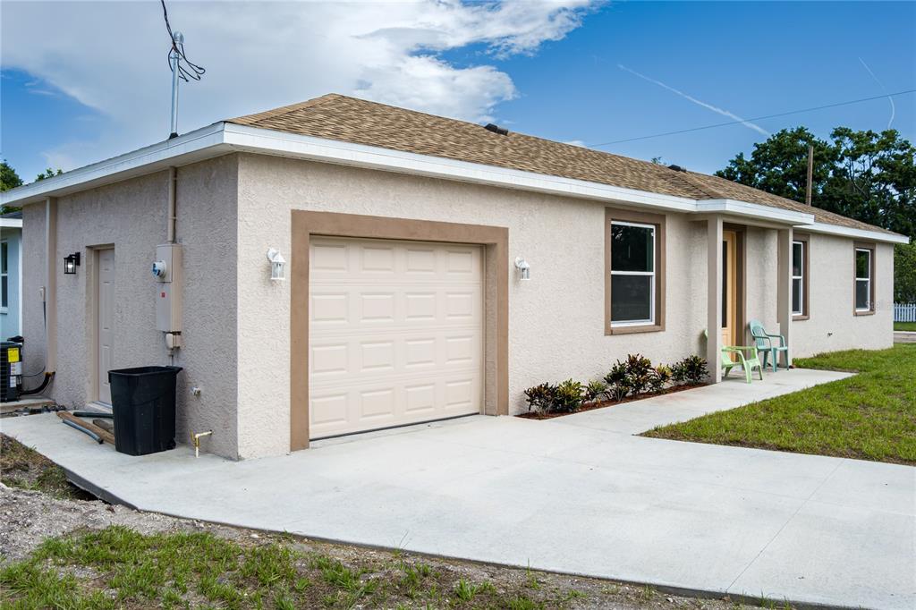 A single-story house with a beige stucco exterior, a one-car garage, and a concrete driveway — 1515 2ND AVENUE W, PALMETTO, FL