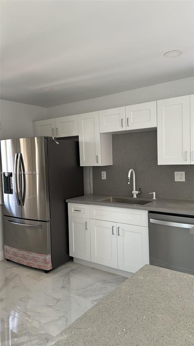 A kitchen features white cabinets, stainless steel appliances, a gray countertop, and marble-look flooring — 331 Lakeview Dr # 101, Weston FL 33326, WESTON, FL