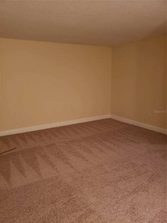 An empty room with beige walls and tan wall-to-wall carpeting — 4801 S TEXAS AVENUE UNIT 4801D, ORLANDO, FL