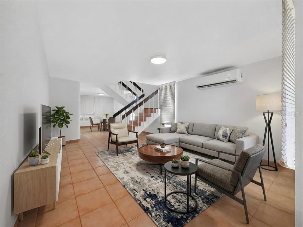 A living room with tile floors, a sectional sofa, and a staircase in the background — F-23 TOPACIO ST. URB PASEO REAL, DORADO, PR