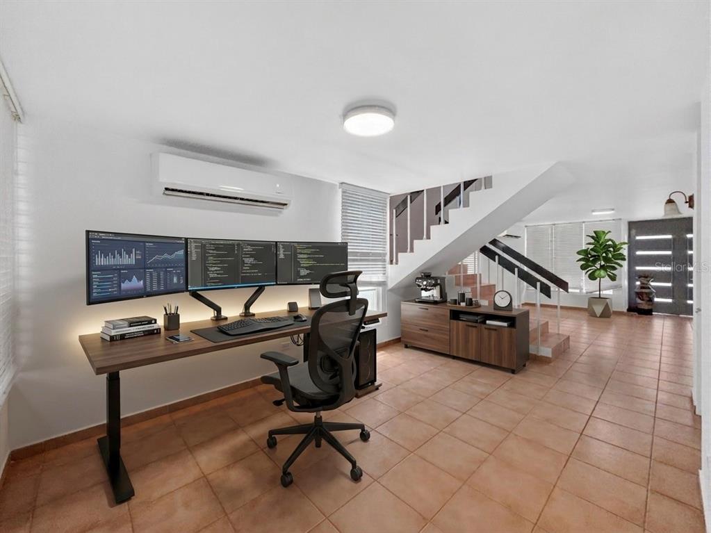 A home office features a triple-monitor desk setup, tiled floors, and stairs leading upward — F-23 TOPACIO ST. URB PASEO REAL, DORADO, PR