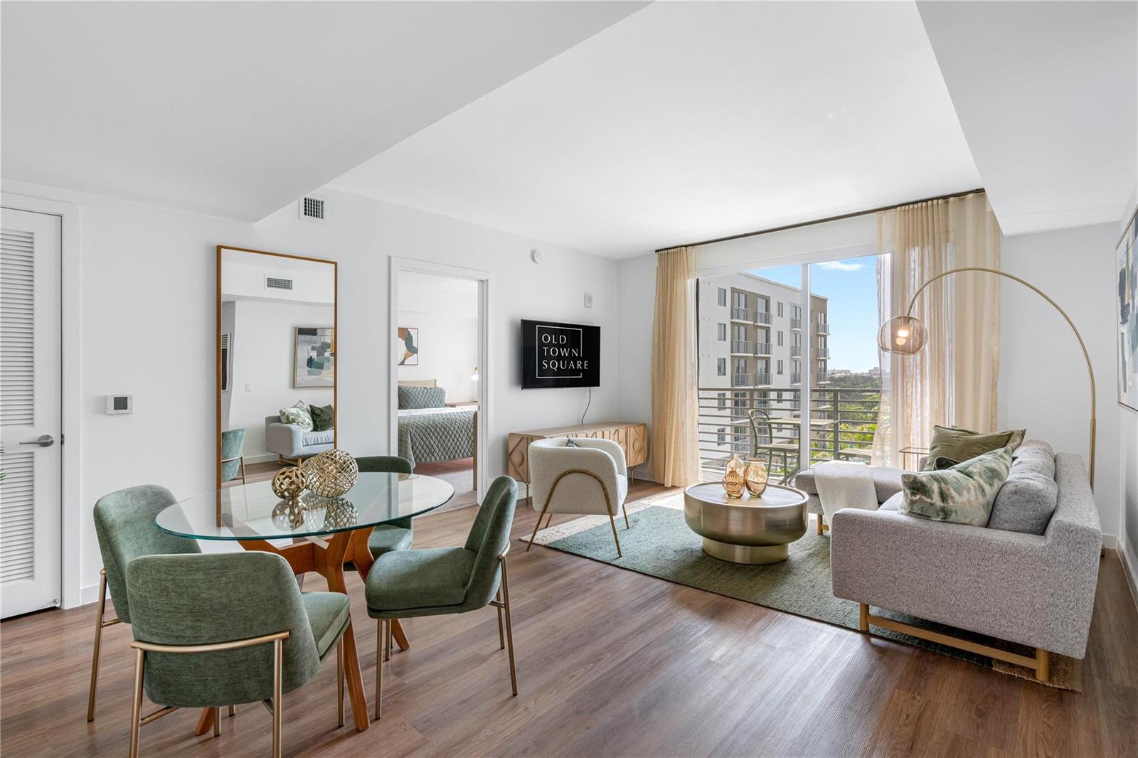 A modern living and dining area with a glass table, green chairs, and balcony access — 200 NE 1st Avenue # 1027, Pompano Beach FL 33060, POMPANO BEACH, FL