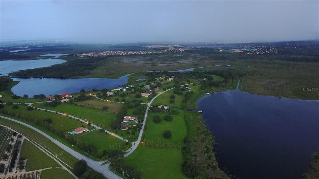 An aerial view shows houses situated on green land between two large lakes at dusk — Lot 39 ROYAL PALM DRIVE, GROVELAND, FL
