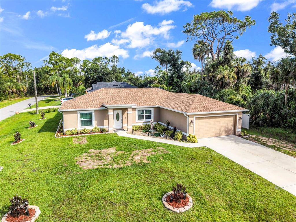 A single-story house with a tan exterior, a brown shingled roof, and a concrete driveway — 4323 MICHALER STREET, NORTH PORT, FL