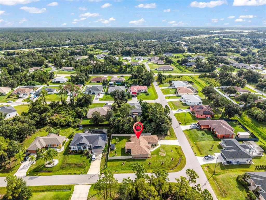 An aerial view shows a single-story suburban house with a fenced yard and surrounding neighborhood — 4323 MICHALER STREET, NORTH PORT, FL