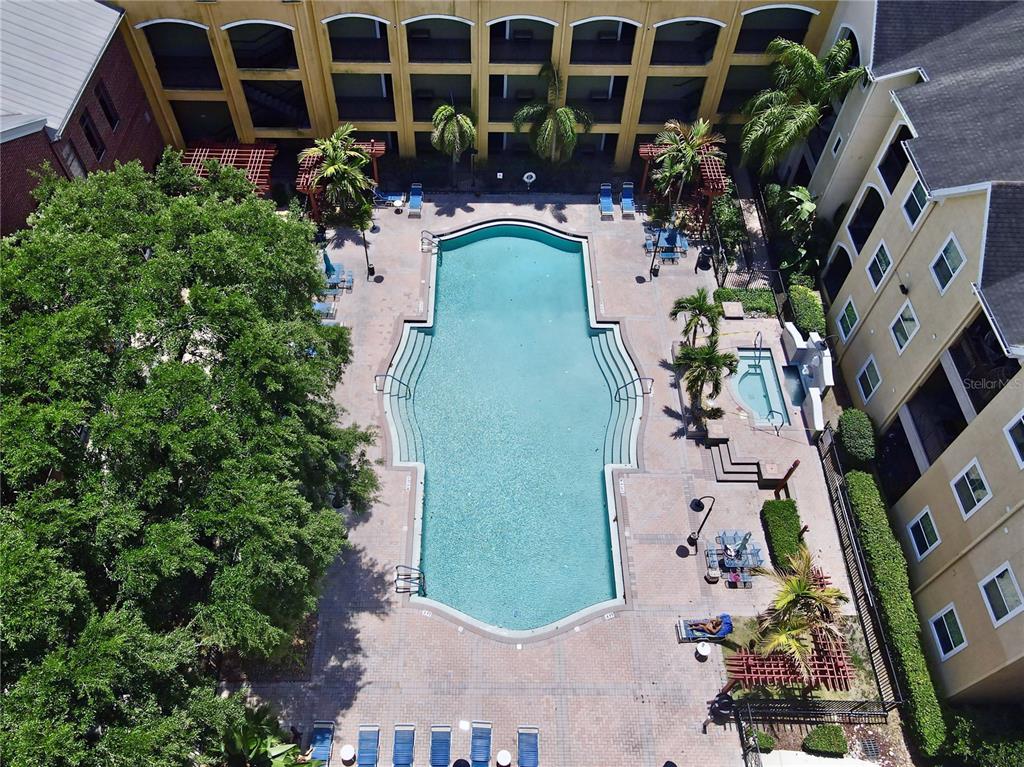 An aerial view shows a swimming pool and hot tub surrounded by a patio and buildings — 1810 E PALM AVENUE UNIT 5122, TAMPA, FL