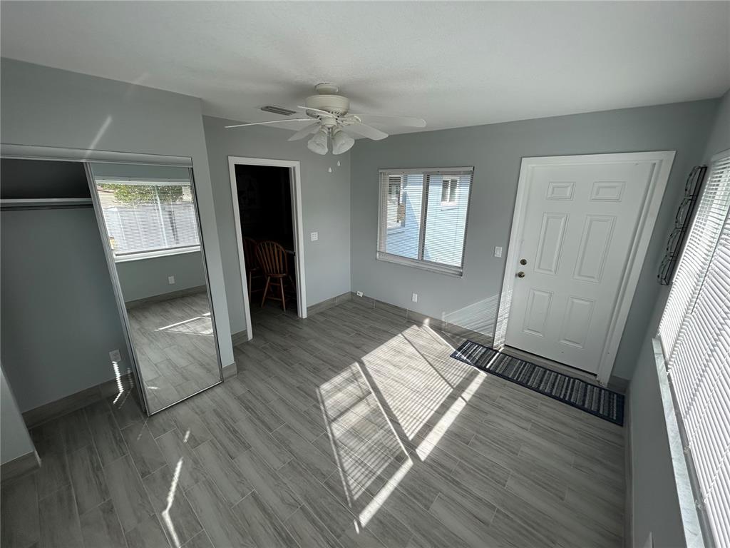 A room with gray walls, wood-look tile flooring, a mirrored closet, and a white door — 21570 SW RAINTREE STREETS, DUNNELLON, FL