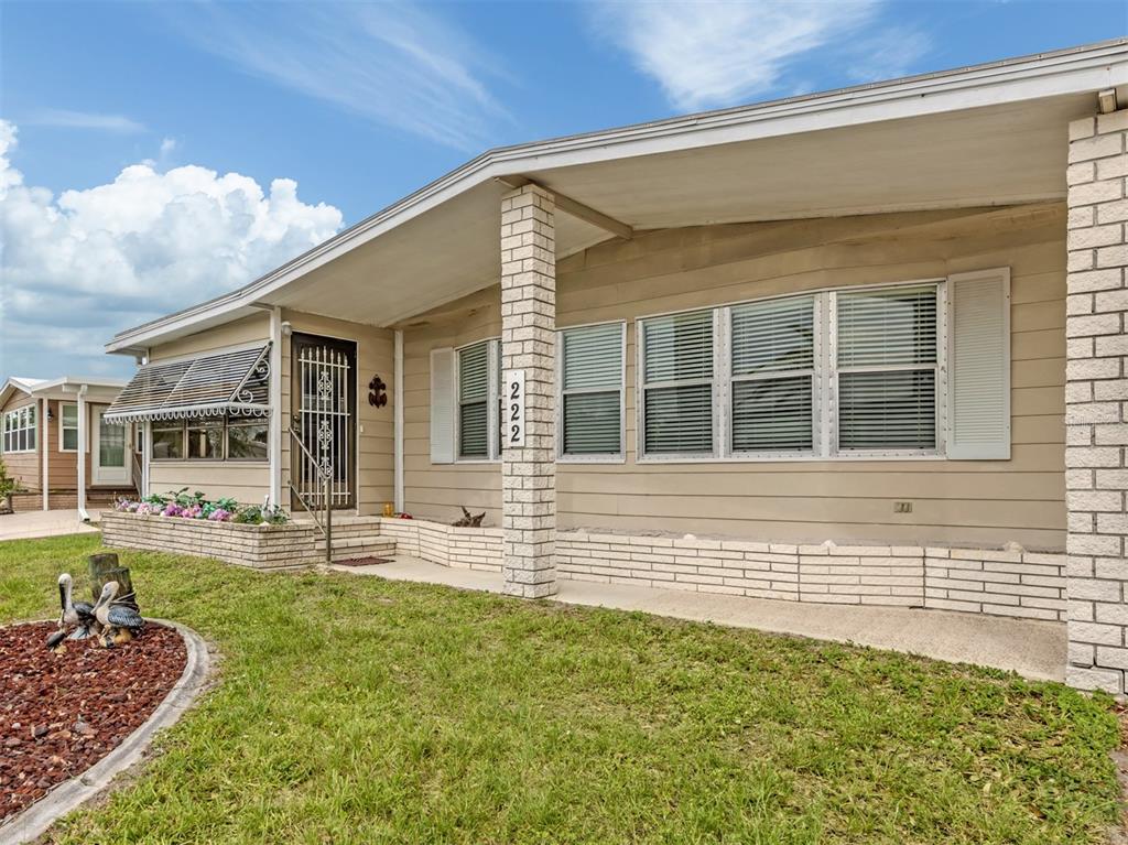 A single-story house with tan siding, a brick pillar, and a front porch — 222 SCHOONER STREET, NORTH PORT, FL