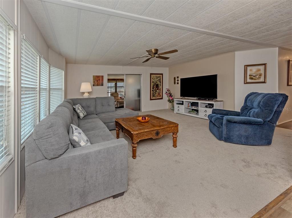 A living room features a gray sectional sofa, a blue recliner, and a wooden coffee table — 222 SCHOONER STREET, NORTH PORT, FL