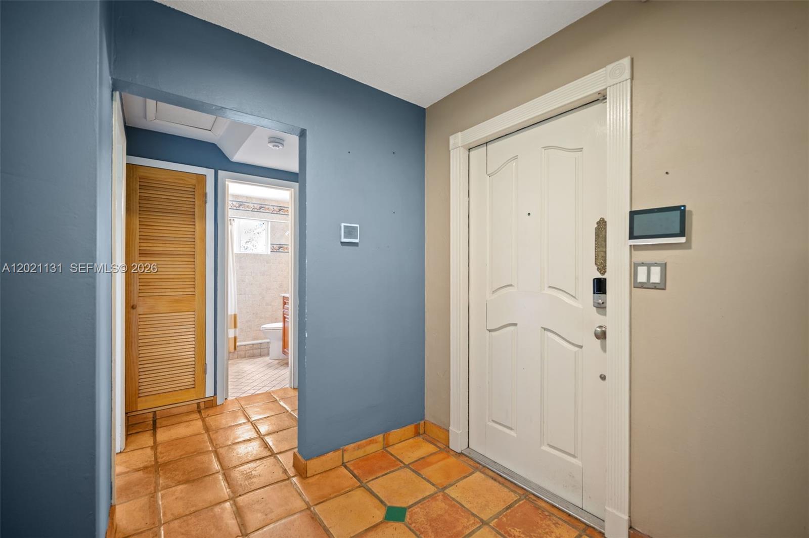 An entryway features terracotta tile flooring, a white front door, and a blue accent wall — 4512 SW 37th Ave, Dania Beach FL 33312, DANIA BEACH, FL