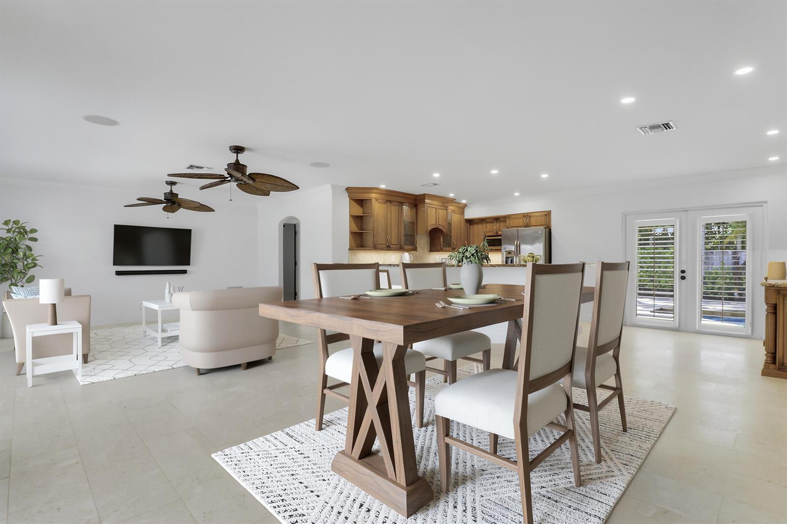 An open-concept living and dining area features wooden furniture, ceiling fans, and a kitchen — 19931 Jasmine Drive, Jupiter FL 33469, JUPITER, FL