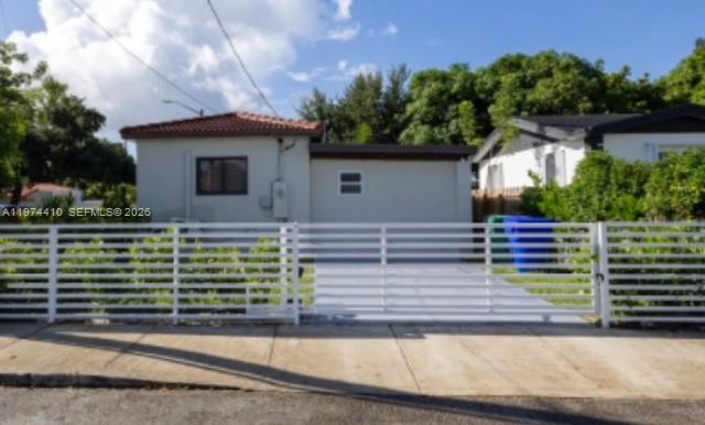 A single-story house with a white horizontal fence and a paved driveway in front — 5180 NW 14th Ave # B, Miami FL 33142, MIAMI, FL