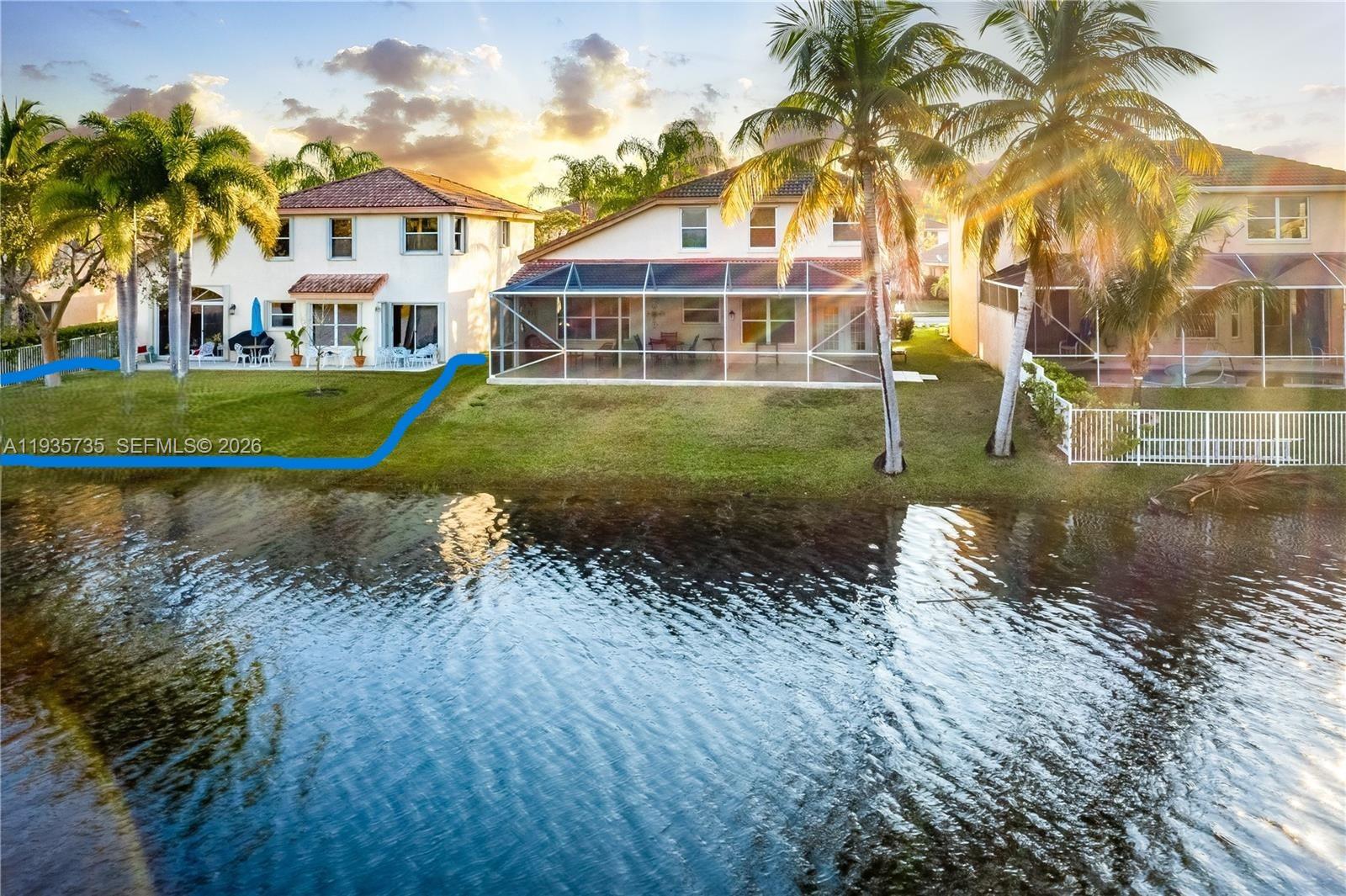 An exterior view of two waterfront houses with screened-in patios and palm trees — 2824 SW 183rd Ave, Miramar FL 33029, MIRAMAR, FL